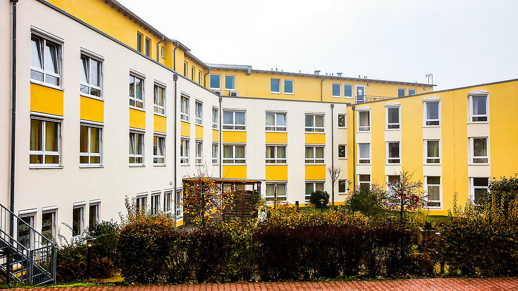 Weiß-gelber Fassadenanstrich an einem Seniorenwohnheim