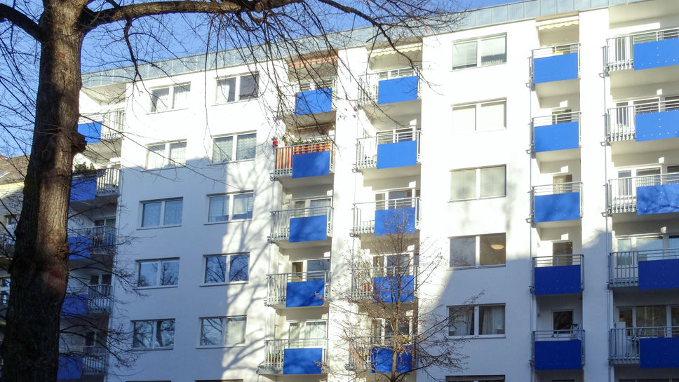 Mehrstöckiges Mehrfamilienhaus mit blauen Balkonverblendungen