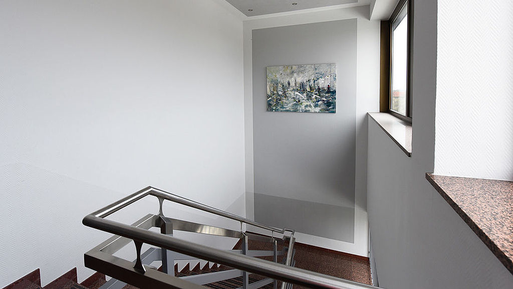 Modernes, hellgrau gestrichenes Treppenhaus in einem Bürogebäude