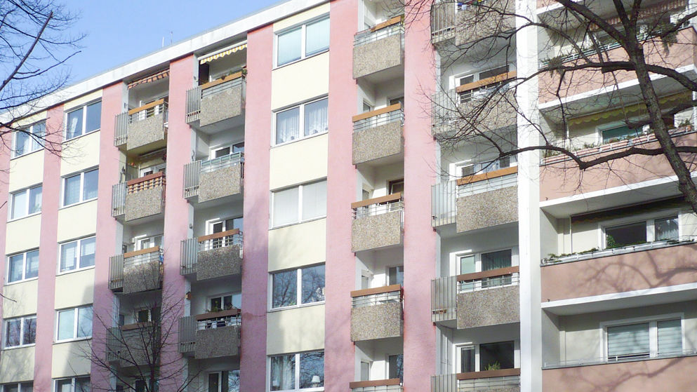 Rosafarbenes Mehrfamilienhaus mit Balkonverblendungen aus Waschbeton